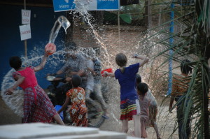 The author and local kids drench a motorcycle rider during Myanmar’s Water Festival. PHOTO: LAURA HODGSON