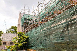 View from the ramp leading from the parking lot on the east side of the church on July 19. Prefinished steel panels replaced slate tiles on the north-facing slope of the east transept. Scaffolding and hoarding on the east side of the nave will soon be relocated.